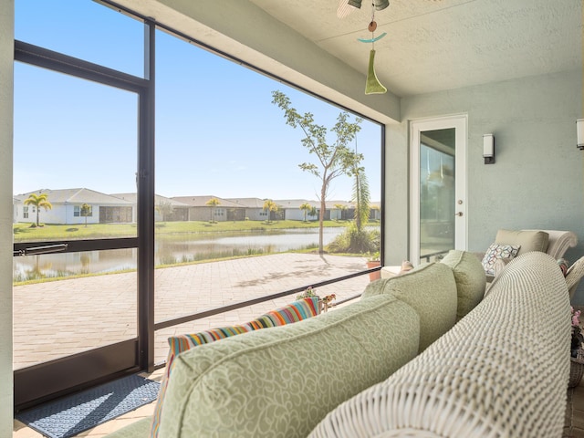 sunroom / solarium featuring a residential view, a water view, and plenty of natural light