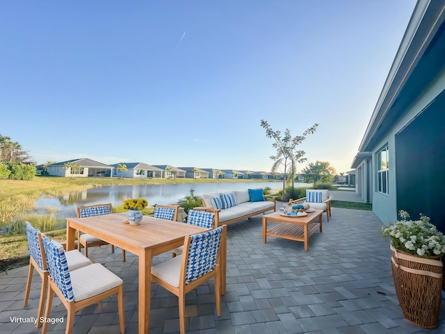 view of patio with outdoor dining area, a water view, and an outdoor hangout area
