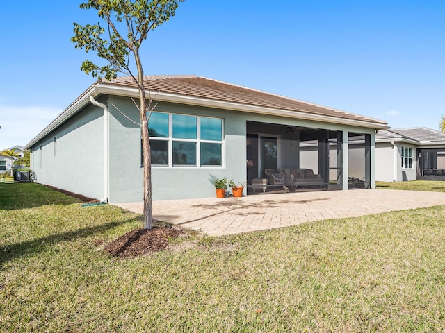 back of house with stucco siding, a yard, a sunroom, a patio area, and a ceiling fan