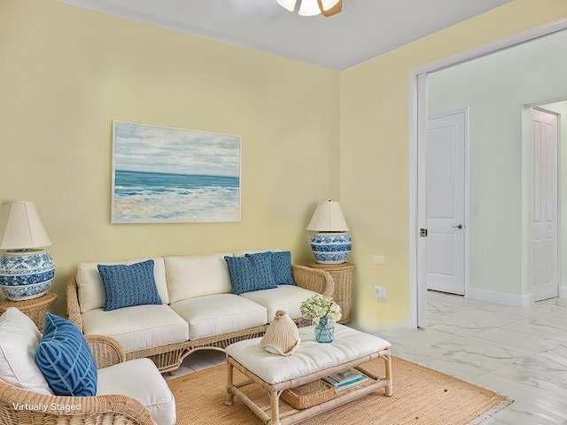 living area featuring marble finish floor and baseboards