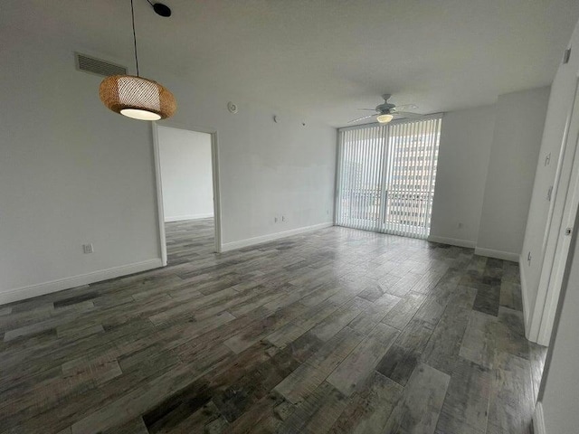 unfurnished room featuring floor to ceiling windows, dark hardwood / wood-style floors, and ceiling fan