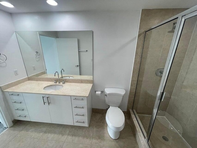 bathroom featuring vanity, an enclosed shower, tile patterned floors, and toilet