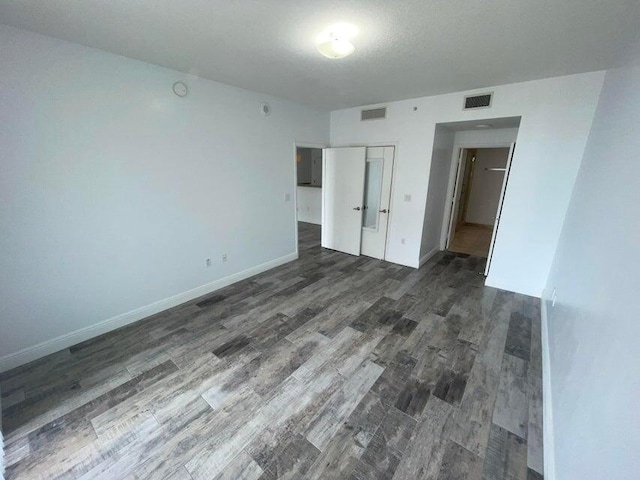 unfurnished bedroom with a closet and dark hardwood / wood-style floors