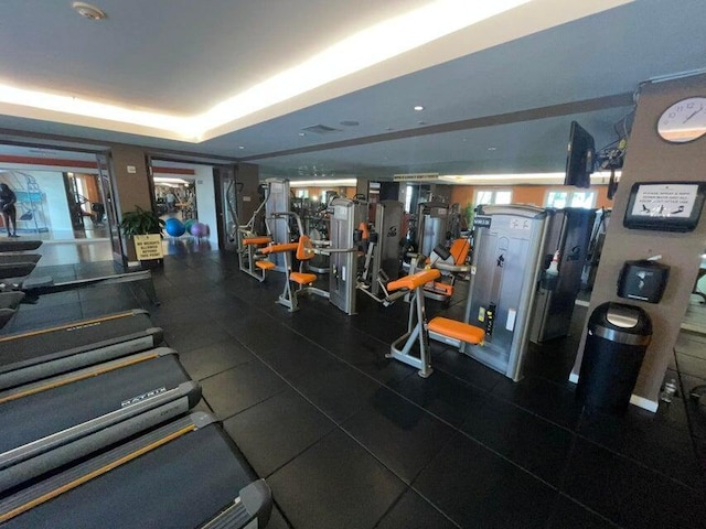 workout area with a tray ceiling