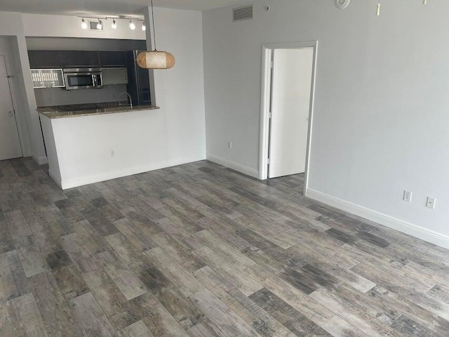 unfurnished living room with dark hardwood / wood-style floors and sink