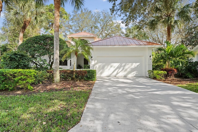 view of front of home featuring stucco siding, concrete driveway, a standing seam roof, metal roof, and a garage