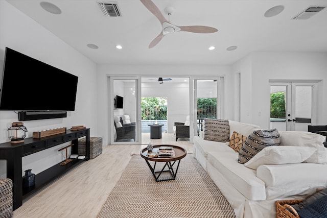 living room featuring recessed lighting, french doors, visible vents, and light wood-style flooring