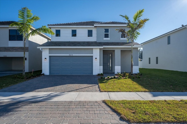 traditional-style home with stucco siding, an attached garage, decorative driveway, and a front yard