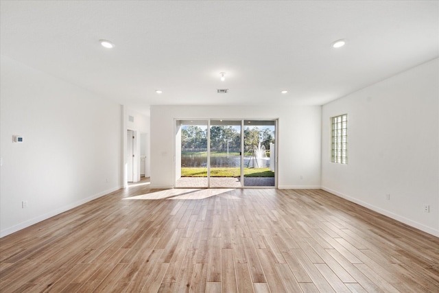 empty room featuring visible vents, recessed lighting, baseboards, and light wood-style floors