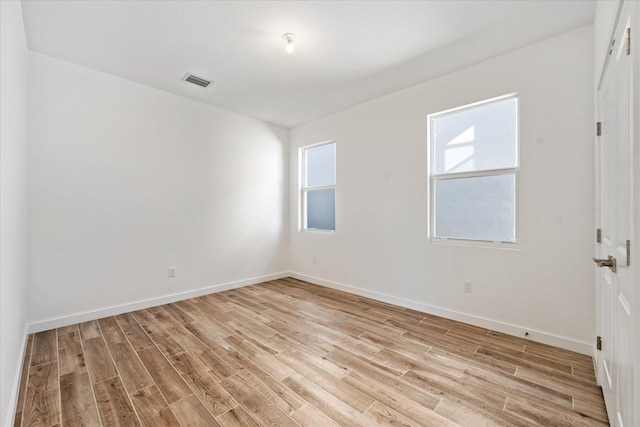 unfurnished room featuring visible vents, baseboards, and light wood-style flooring