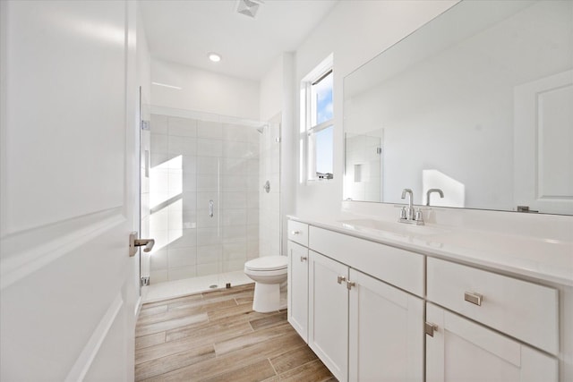 bathroom featuring a shower stall, toilet, visible vents, and wood tiled floor