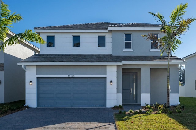 view of front of house featuring stucco siding, decorative driveway, roof with shingles, and an attached garage