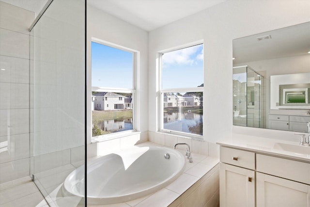 bathroom with a water view, vanity, and shower with separate bathtub