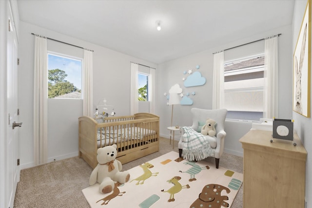 bedroom featuring a crib and light colored carpet