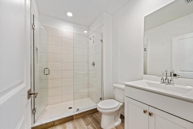 full bathroom featuring vanity, visible vents, wood finish floors, a shower stall, and toilet