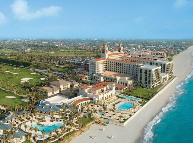 drone / aerial view featuring a water view, a city view, and a beach view