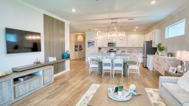 living area with light wood finished floors, recessed lighting, and ornamental molding