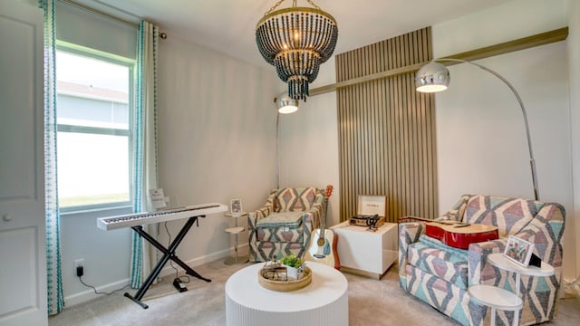 living area with a chandelier, baseboards, and carpet floors