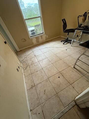 unfurnished office featuring baseboards and light tile patterned floors