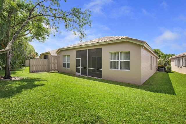 6731 Southport Dr W, Boynton Beach, FL 33472 - rear view of property with stucco siding, a sunroom, fence, and a lawn