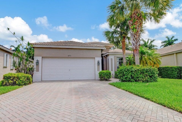 6731 Southport Dr W, Boynton Beach, FL 33472 - mediterranean / spanish-style house featuring a tile roof, stucco siding, an attached garage, decorative driveway, and a front lawn