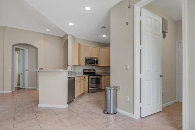 6731 Southport Dr W, Boynton Beach, FL 33472 - kitchen with light countertops, stainless steel appliances, arched walkways, a peninsula, and light brown cabinets