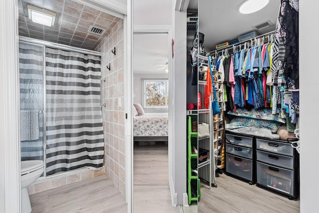 walk in closet with hardwood / wood-style flooring