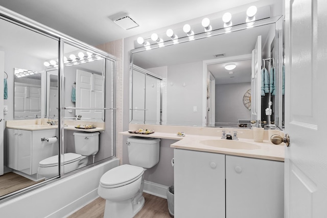 full bathroom featuring enclosed tub / shower combo, vanity, toilet, and hardwood / wood-style floors