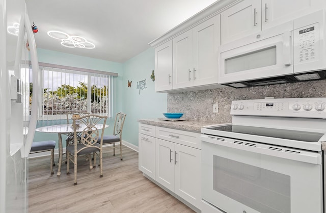 kitchen with white appliances, white cabinetry, light stone counters, tasteful backsplash, and light wood-type flooring