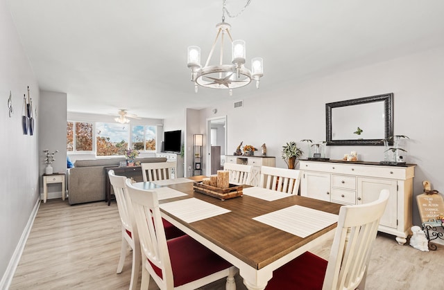 dining area with ceiling fan with notable chandelier and light wood-type flooring