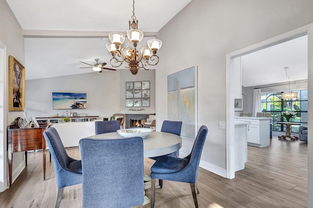 dining space featuring lofted ceiling, a notable chandelier, and light wood-type flooring