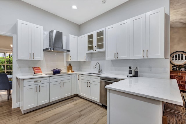 kitchen with white cabinetry, stainless steel dishwasher, wall chimney exhaust hood, and sink