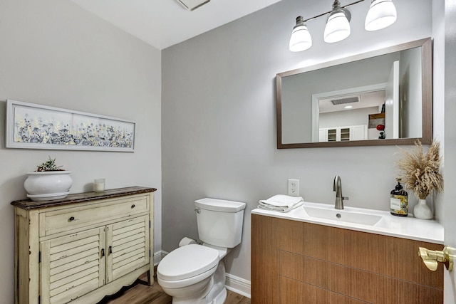 bathroom with vanity, hardwood / wood-style flooring, and toilet