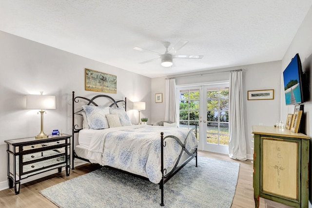 bedroom with hardwood / wood-style floors, french doors, a textured ceiling, and ceiling fan