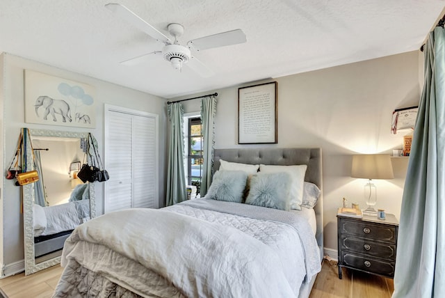 bedroom featuring ceiling fan, light hardwood / wood-style floors, a closet, and a textured ceiling