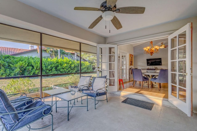 sunroom with ceiling fan with notable chandelier