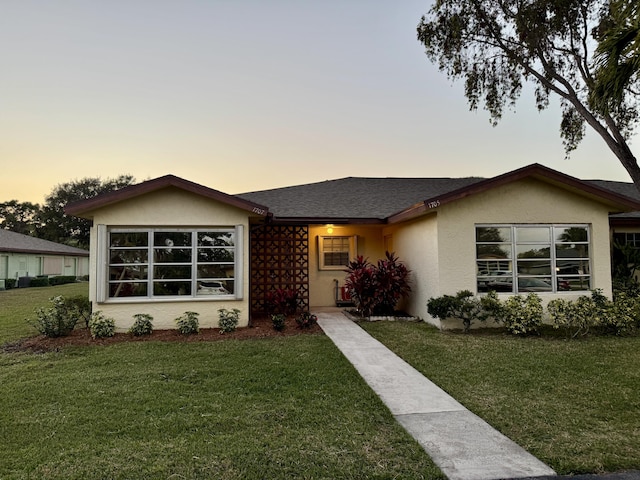 ranch-style home with a lawn