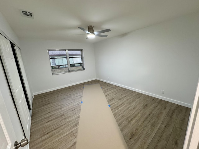 unfurnished bedroom with dark wood-type flooring, ceiling fan, and a closet