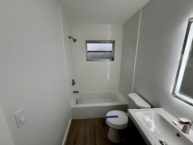 full bathroom with tiled shower / bath, wood-type flooring, toilet, and sink