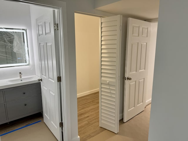 corridor with sink and light hardwood / wood-style flooring