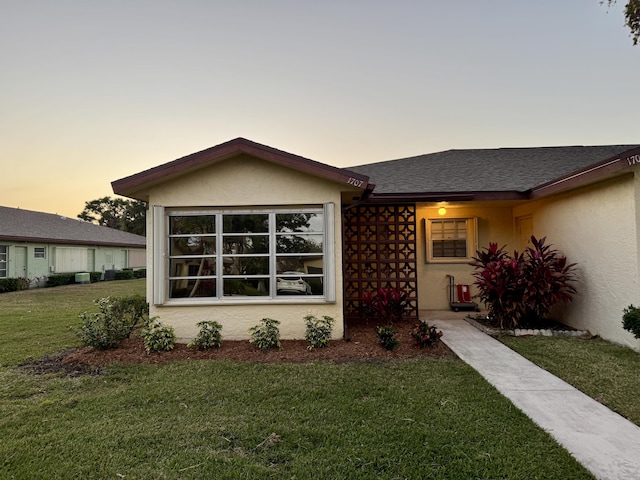 single story home featuring a lawn