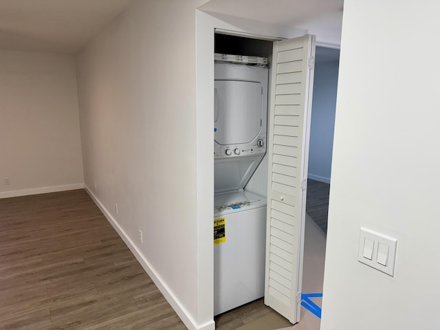 washroom featuring stacked washer and dryer and dark hardwood / wood-style floors