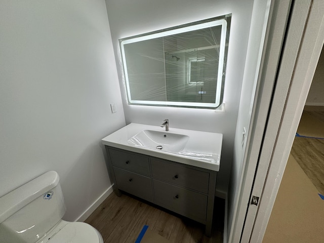 bathroom featuring vanity, hardwood / wood-style flooring, and toilet