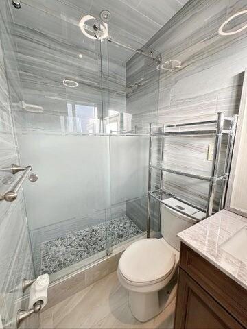 bathroom with vanity, an enclosed shower, and toilet