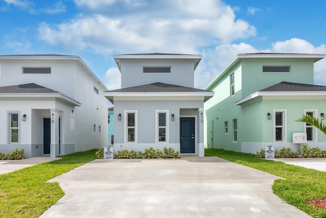 412 NW 13th Ave, Boynton Beach, FL 33435 - view of front of property with a shingled roof, a front lawn, and stucco siding