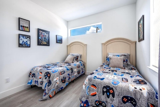 bedroom featuring baseboards and wood finished floors