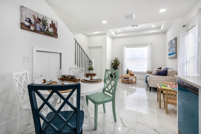 dining space with visible vents, marble finish floor, a raised ceiling, and stairs