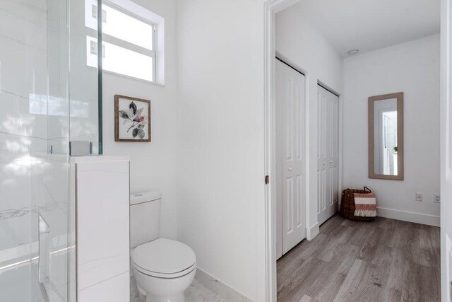 412 NW 13th Ave, Boynton Beach, FL 33435 - full bathroom with a shower stall, toilet, baseboards, and wood finished floors