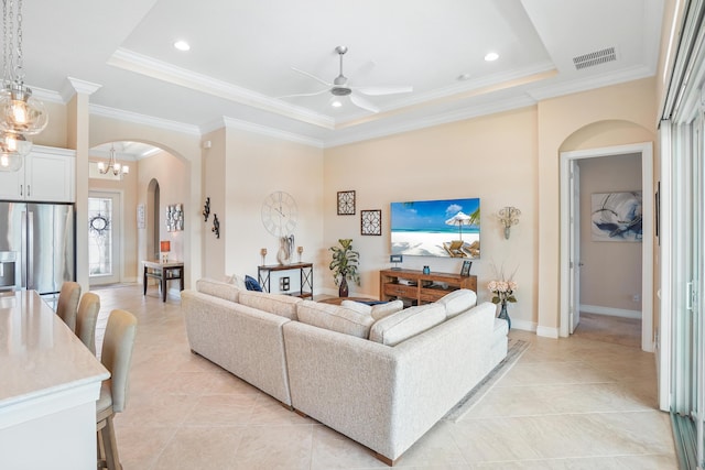 living room with ornamental molding, a raised ceiling, and ceiling fan with notable chandelier