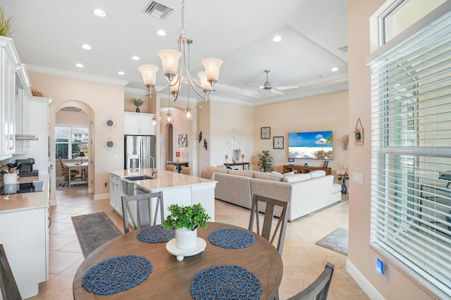 dining room featuring crown molding, ceiling fan with notable chandelier, sink, and light tile patterned floors